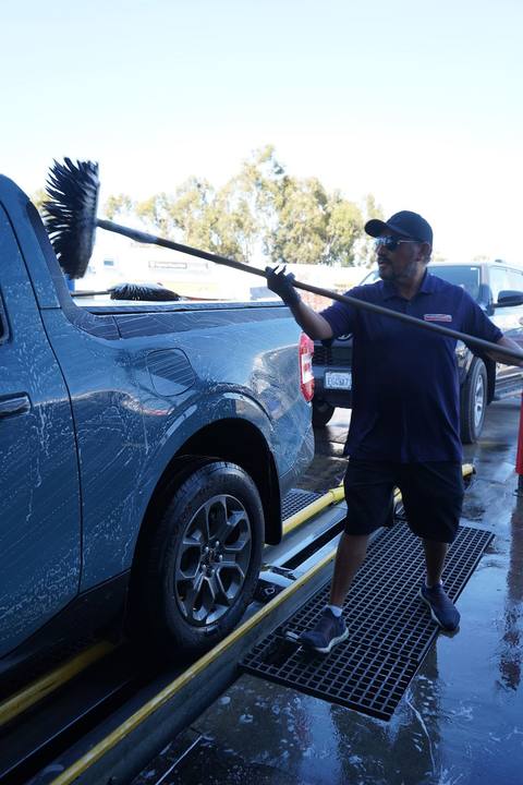 Crew member brushing a Ford Maverick before the tunnel