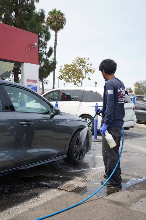 Crew member pressure rinsing a grey Audi S3