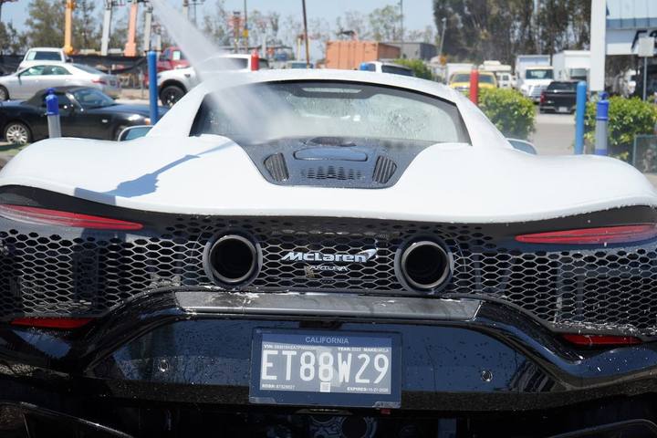 Rear of a white McLaren Artura getting a pressure rinse