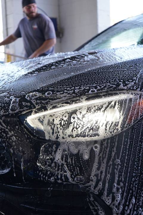 Black Mercedes C-Class covered in foam during hand prep