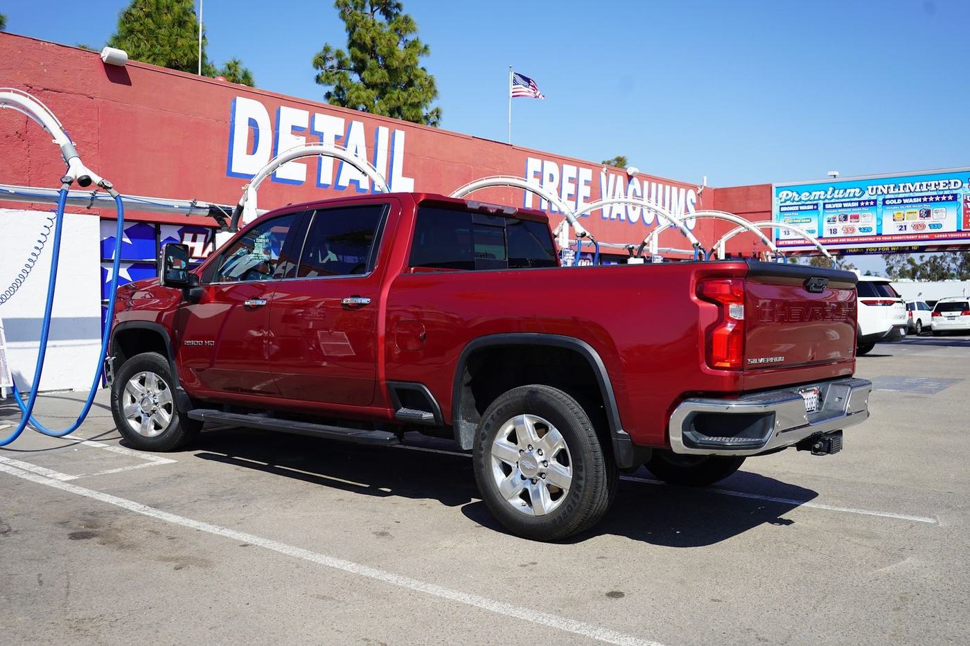 Red Chevy Silverado in front of the Detail and Free Vacuums sign