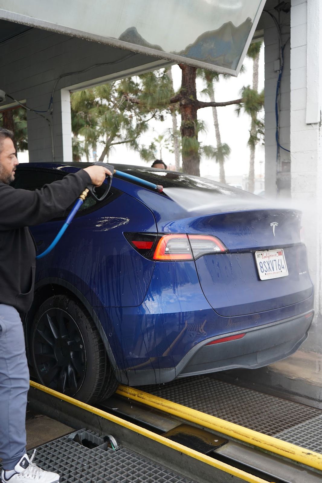 Blue Tesla Model Y getting rinsed in the tunnel