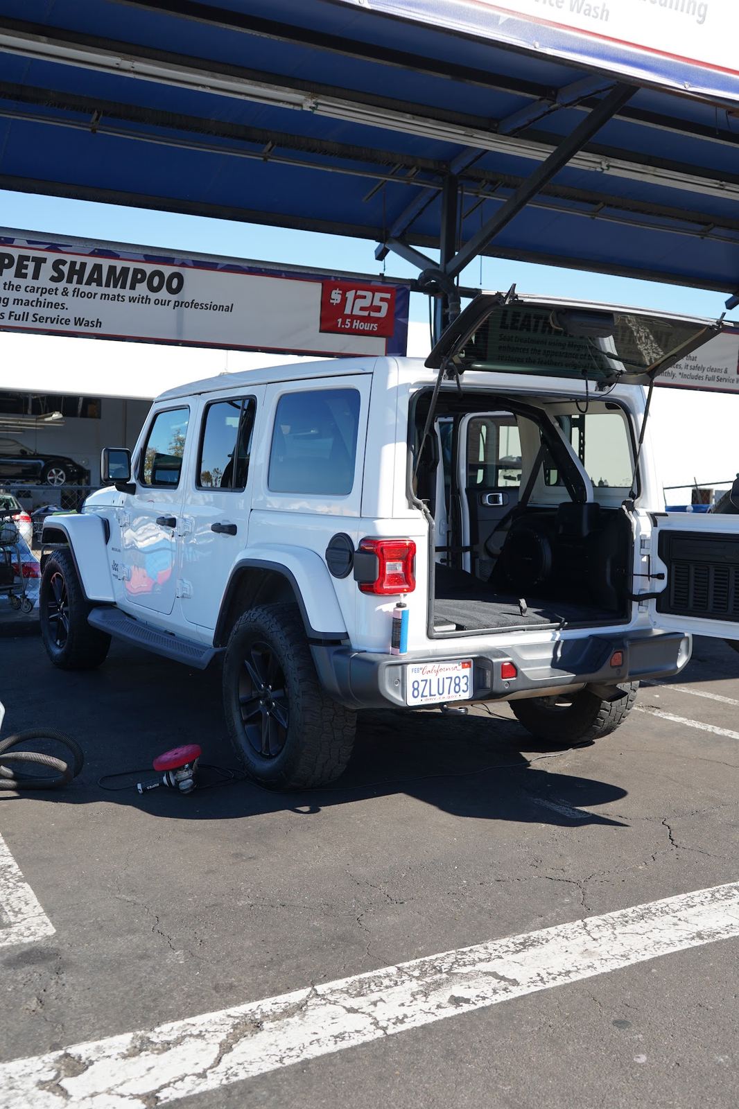 White Jeep Wrangler in the carpet shampoo bay