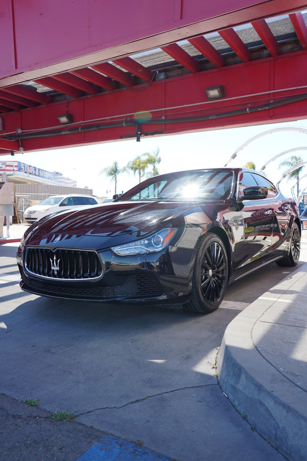 Black Maserati Ghibli under the red detail canopy