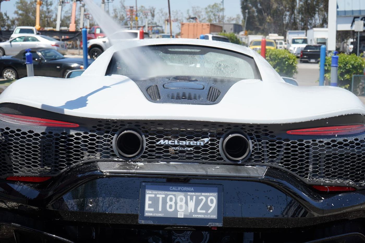 Rear of a white McLaren Artura getting a pressure rinse