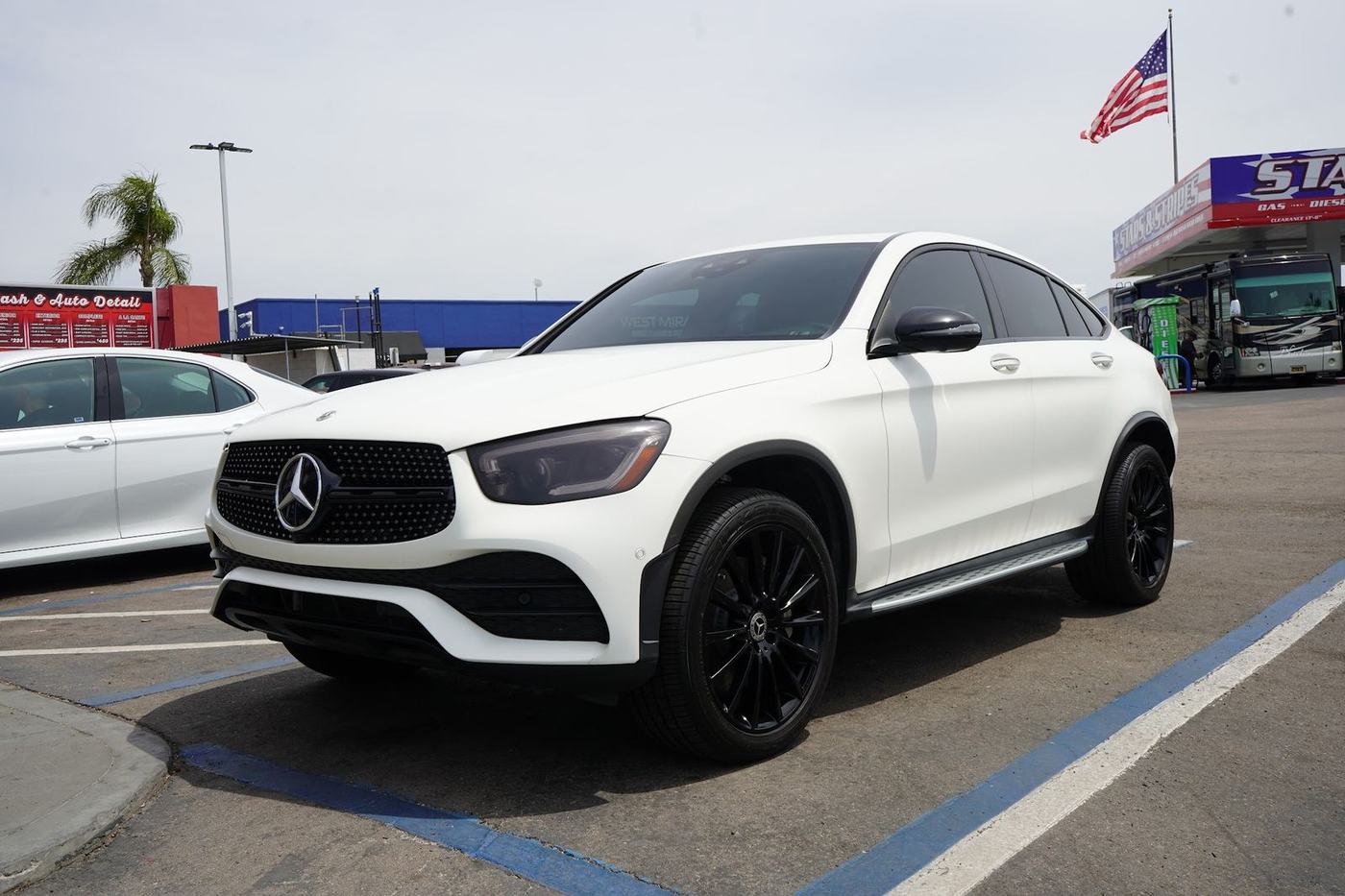 White Mercedes GLC coupe on the lot with the American flag