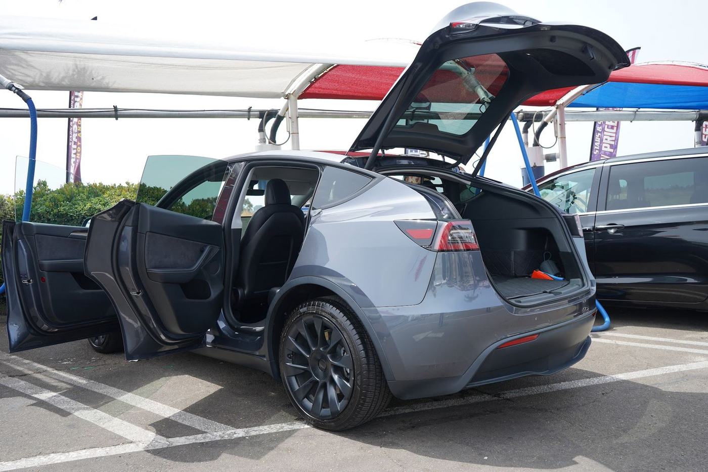 Grey Tesla Model Y with the doors and hatch open at the vacuums